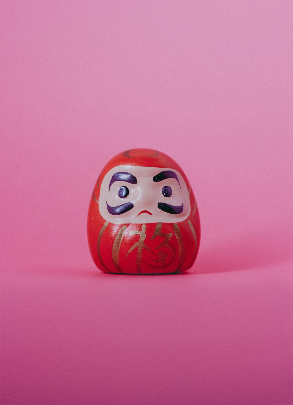 red and white Daruma doll figurine