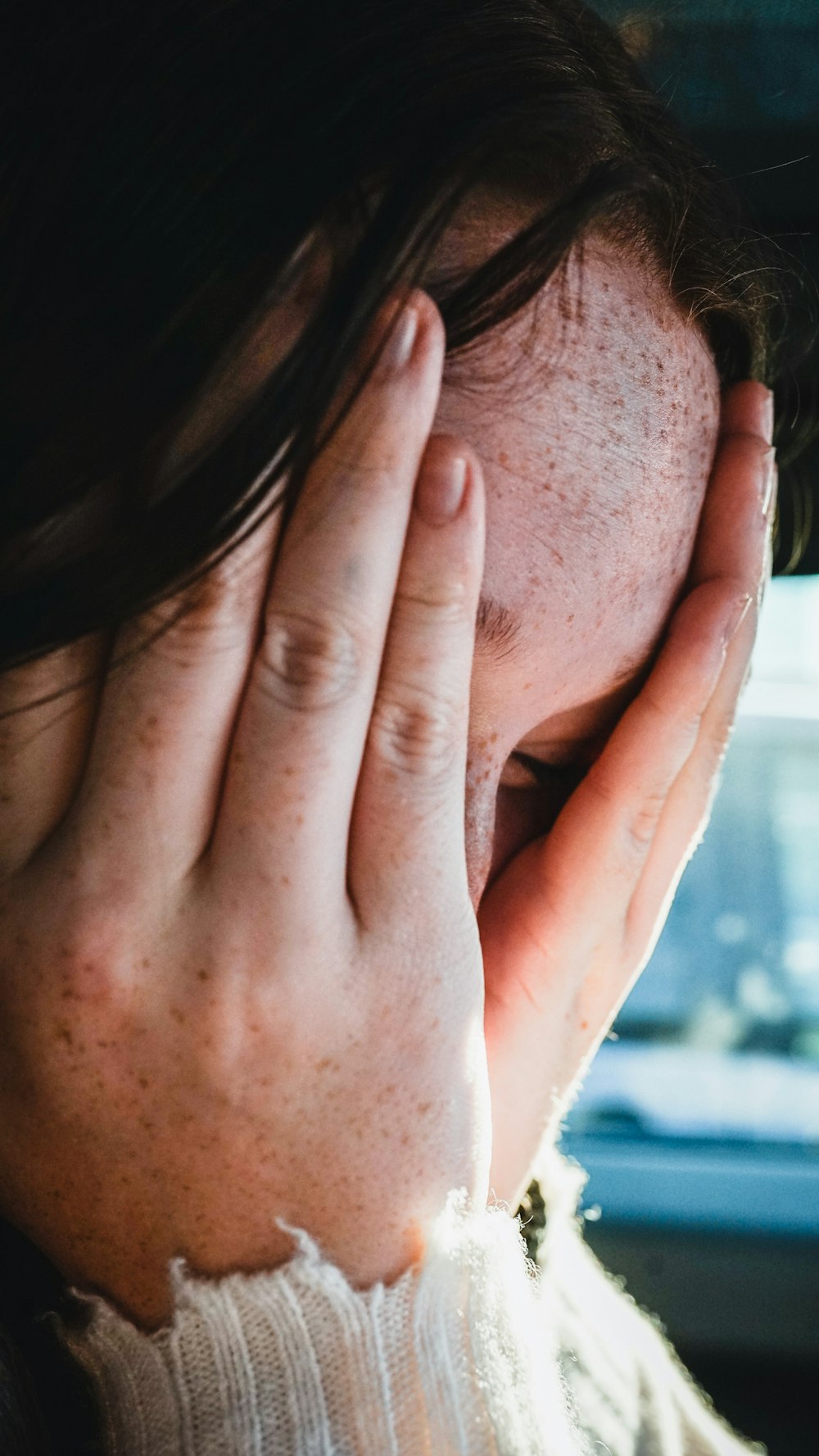 woman covering her face