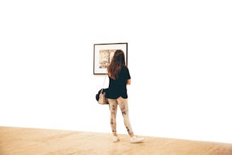 woman in black shirt standing and facing wall