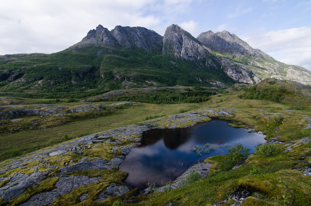 green mountain near body of water