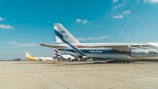 Cargo planes being loaded at Dubai airport under a clear blue sky.