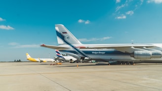 A cargo plane being loaded on the tarmac under a clear blue sky, prepared for air freight.