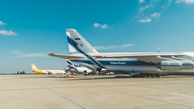 Cargo planes being loaded at Dubai airport under a clear blue sky.