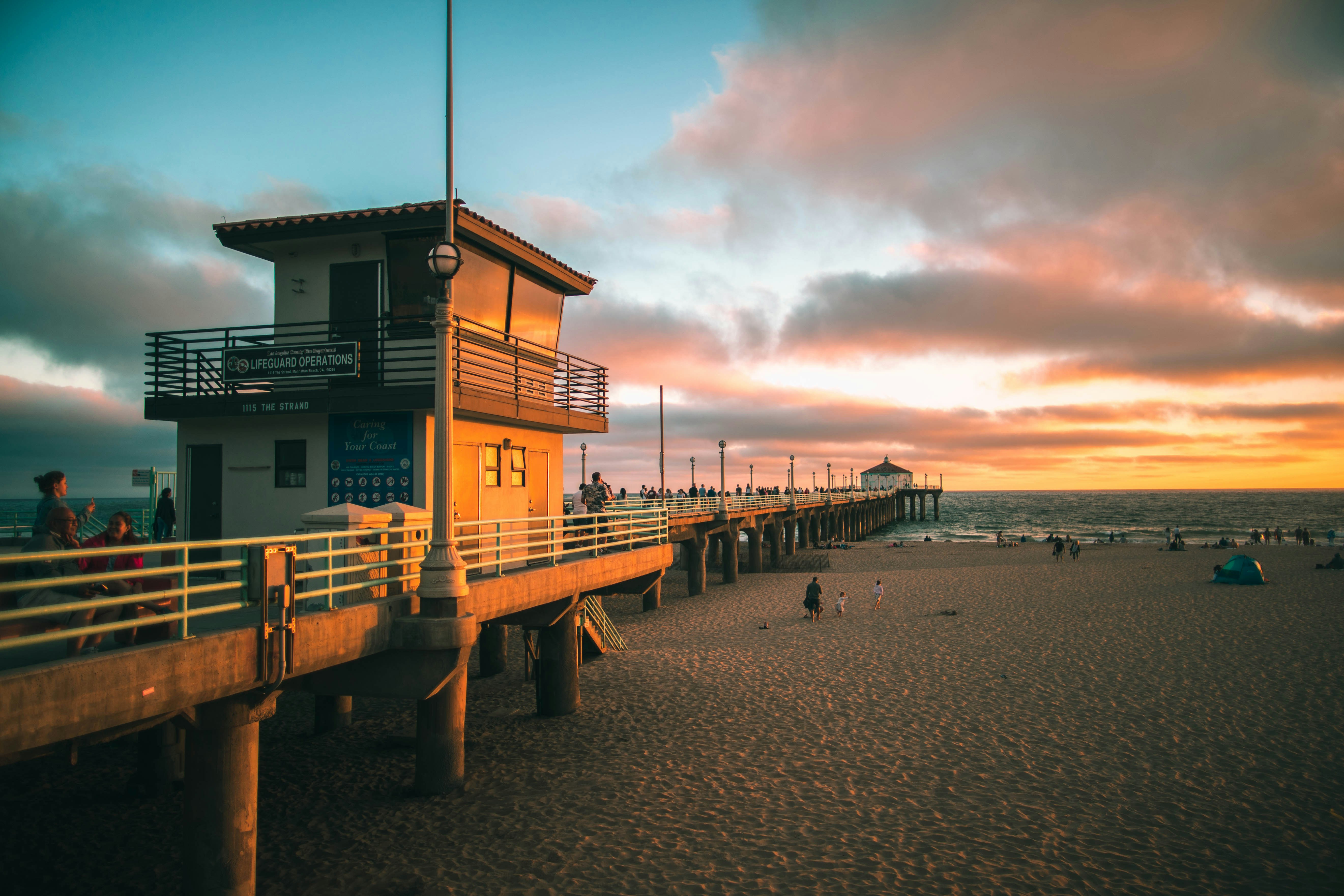 a lifeguard tower on the beach at sunset