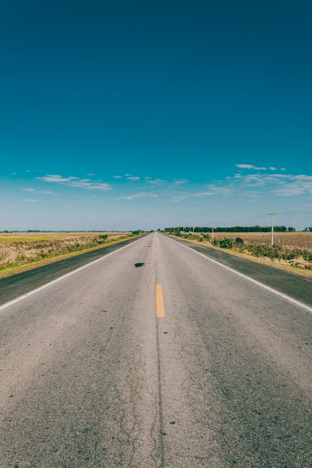 empty paved road under blue sky