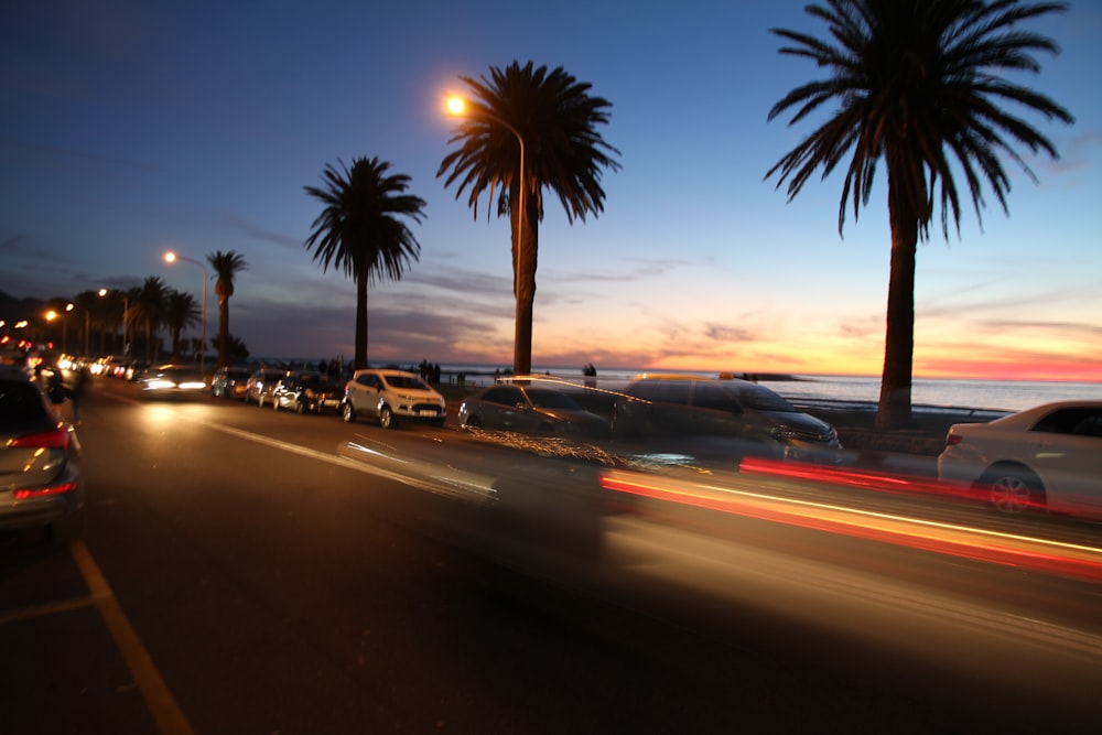 long exposure photography of vehicles and palm tree