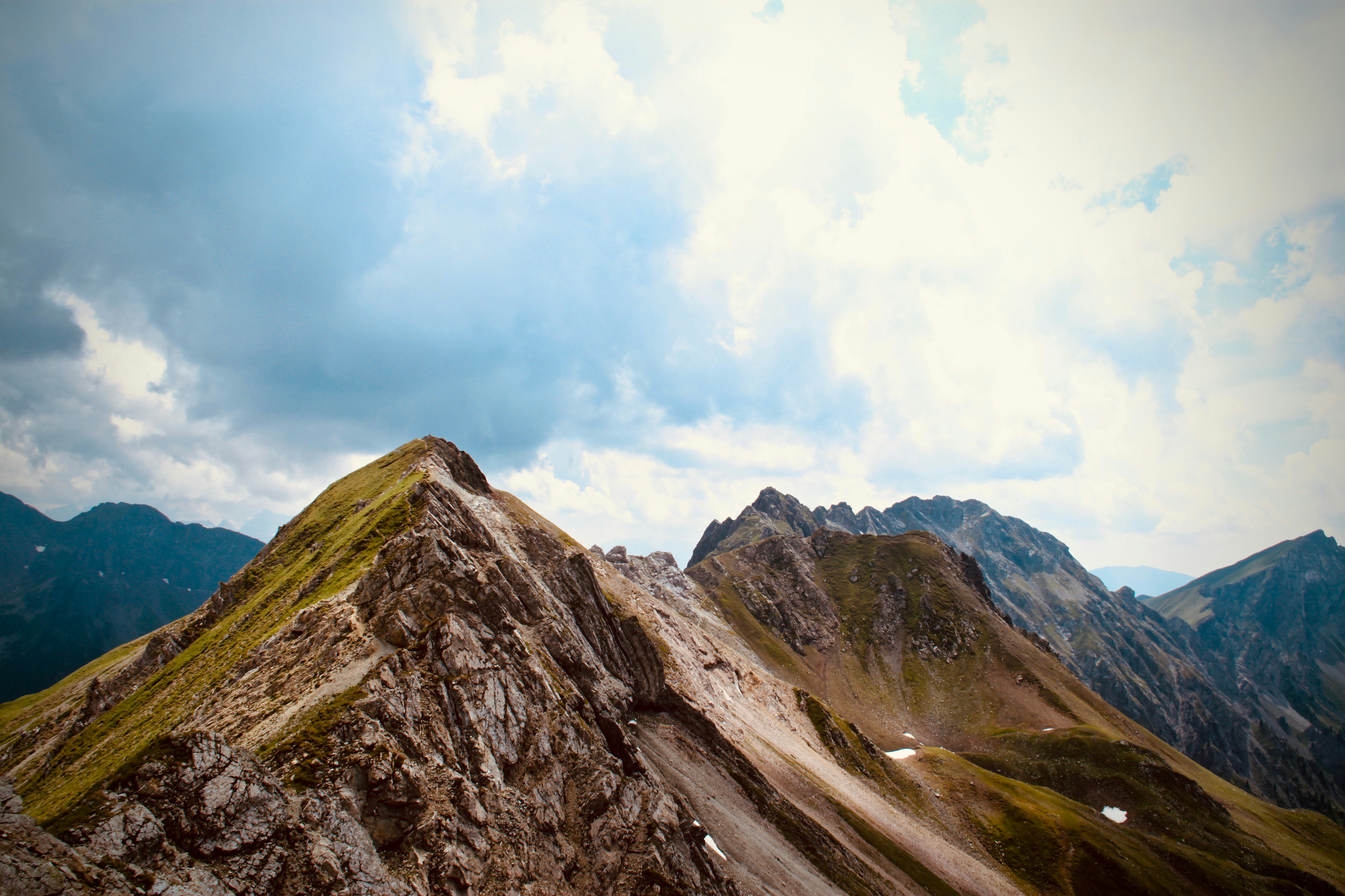 mountain range under cloudy sky