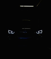 black car in the dark with lighted daytime running lights
