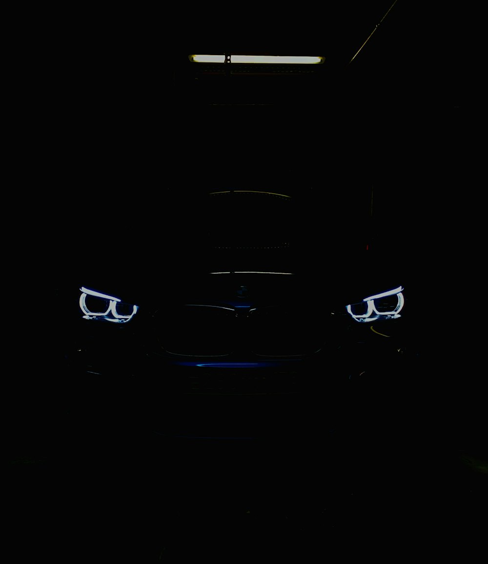 Schwarzes Auto im Dunkeln mit beleuchtetem Tagfahrlicht