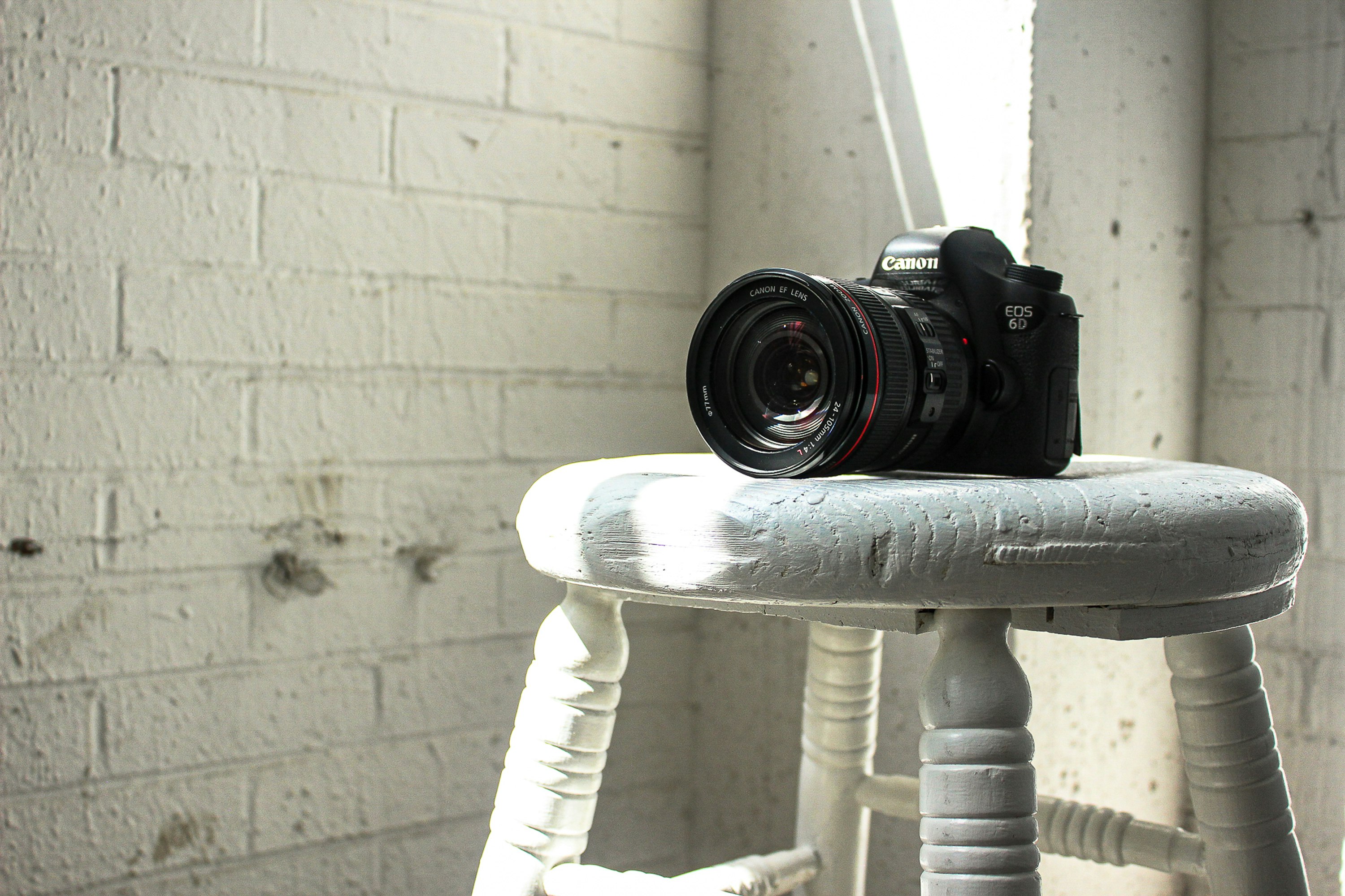 black Canon DSLR camera on stool
