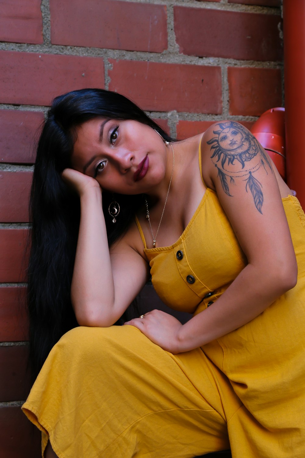 woman wearing yellow romper near red wall