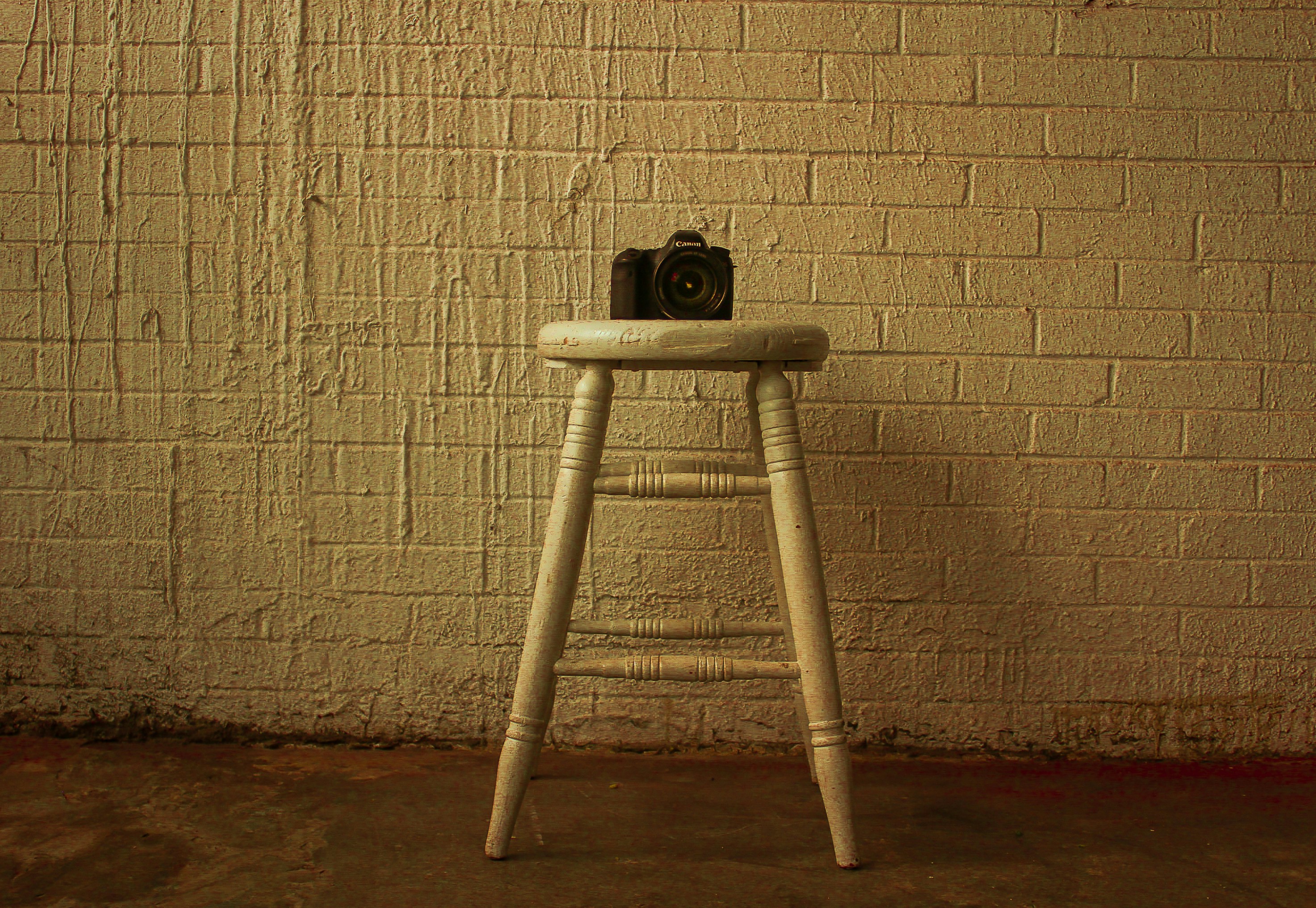 camera on beige wooden chair