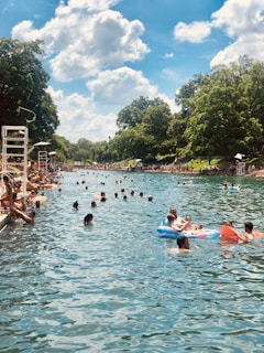 people on river under clear blue sky