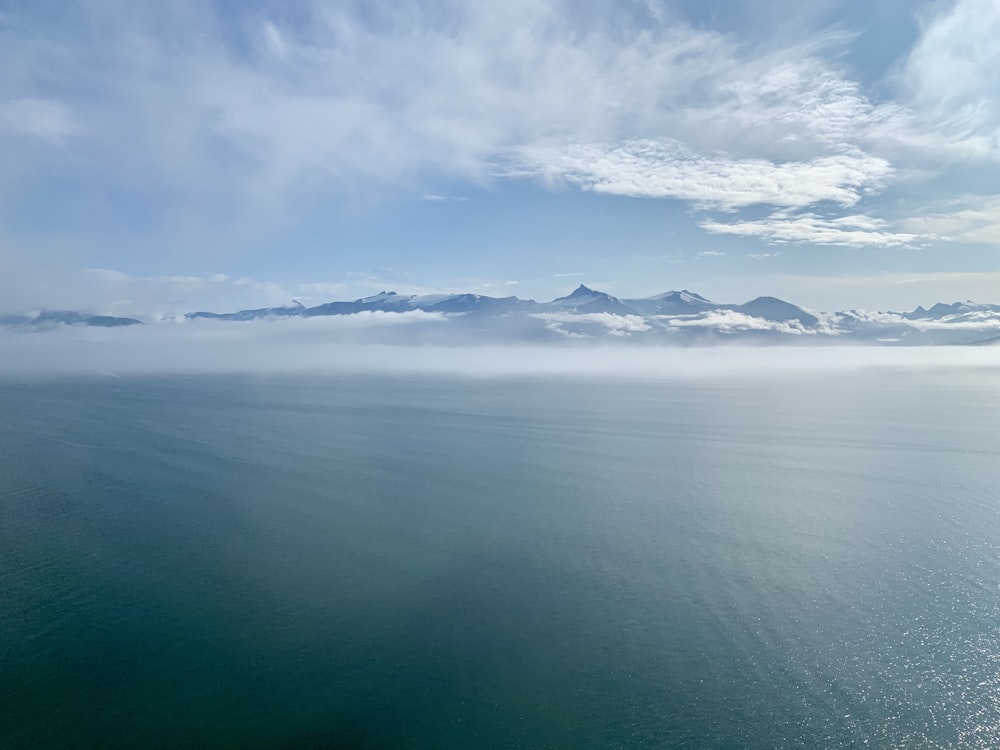 body of water near mountain during daytime