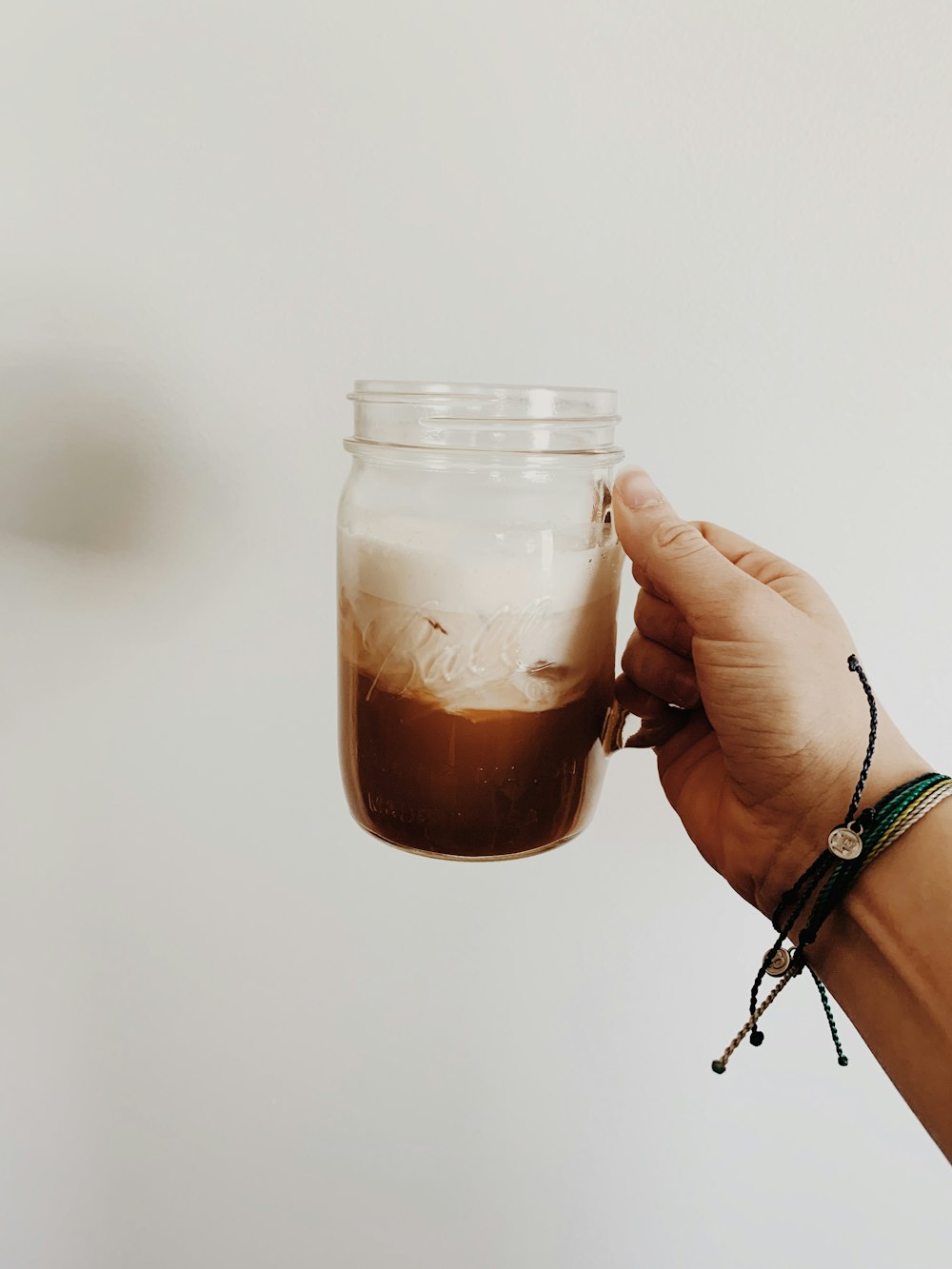 person holding glass mug