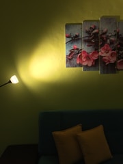 A cozy living room featuring a striking fluted wall panel in soft green hues, complemented by warm lighting.