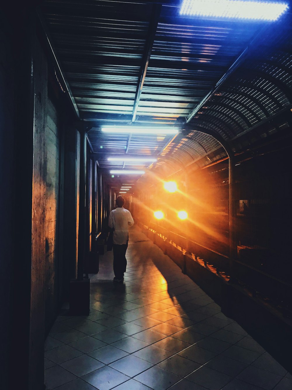 person walking towards train running on trak