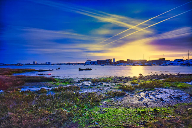 A vibrant photo of the Veracruz port at sunset with fishing boats and colorful buildings.