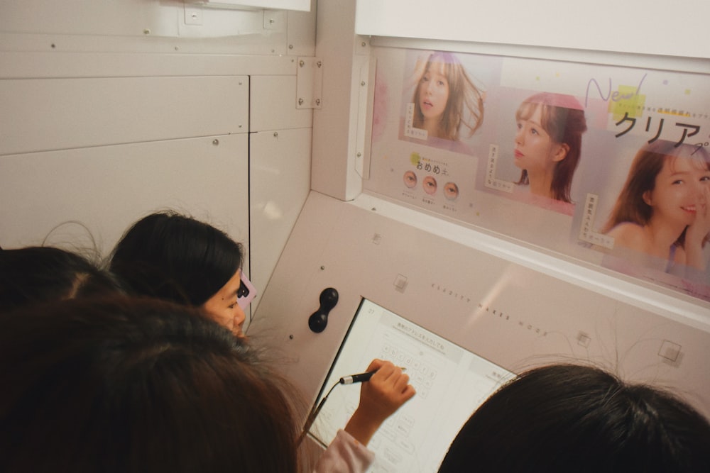 man writing on monitor with woman poster