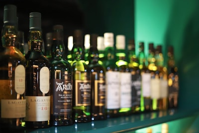 Rows of whisky bottles with warm lighting highlighting their amber hues.