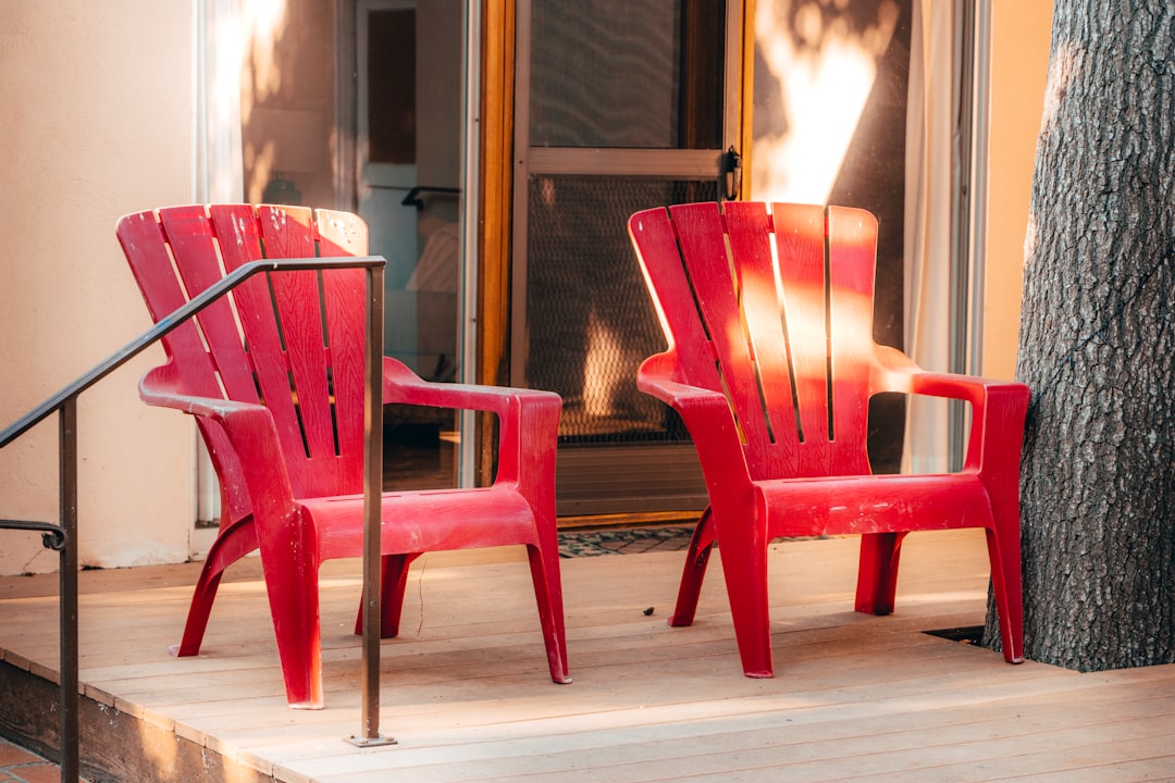 two red armchairs beside tree and closed door