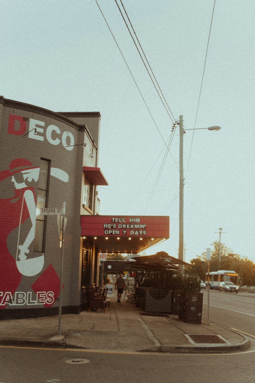 gray utility pole in front of gray and red building