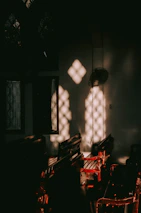 Sunlight filtering through carved wooden screens in a serene riad room.