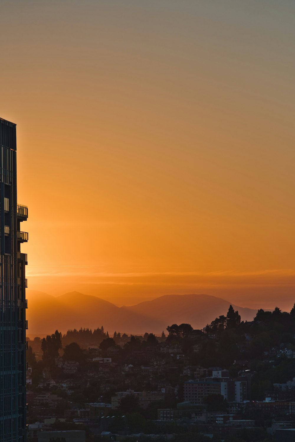 city building across mountain during sunset