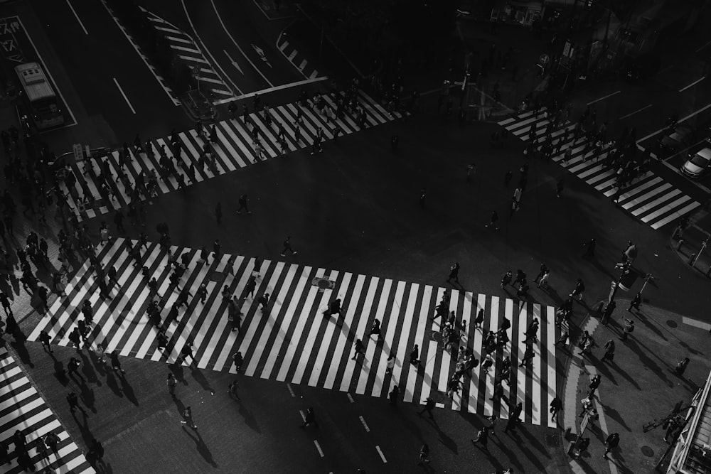grayscale photography of people walking on pedestrian lane