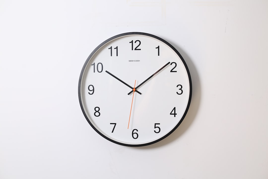  round analog wall clock pointing at 10:09 clock