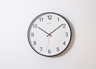 round analog wall clock pointing at 10:09