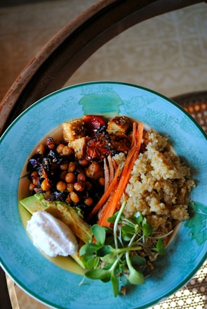 Soft beige ceramic bowl filled with a colorful, nutrient-rich quinoa salad.