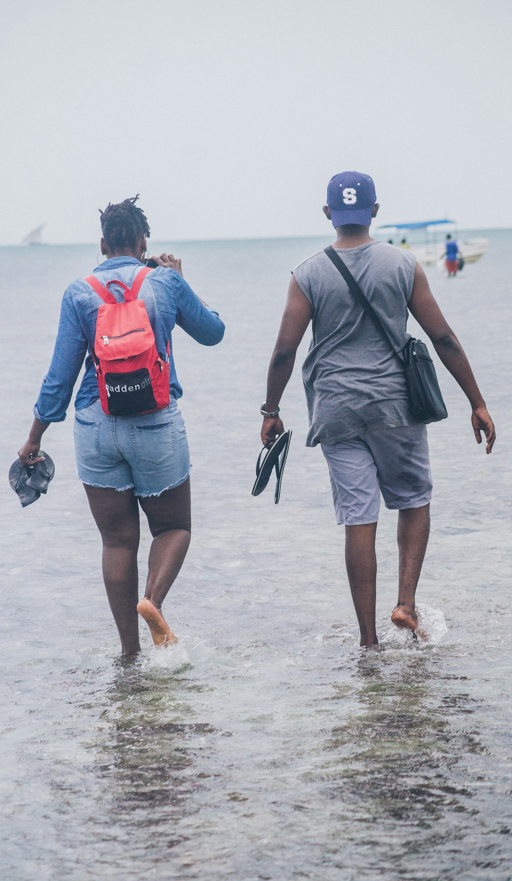 man and woman walking on body of water