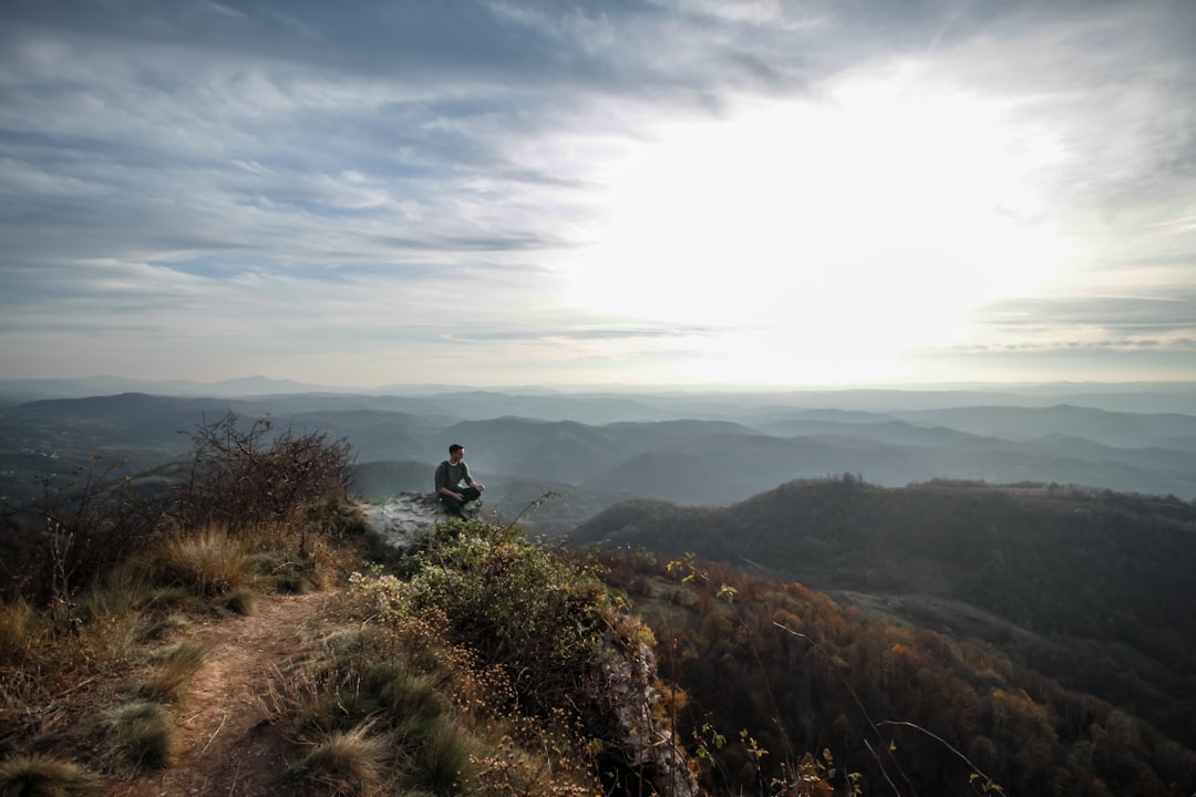 man sits on cliff