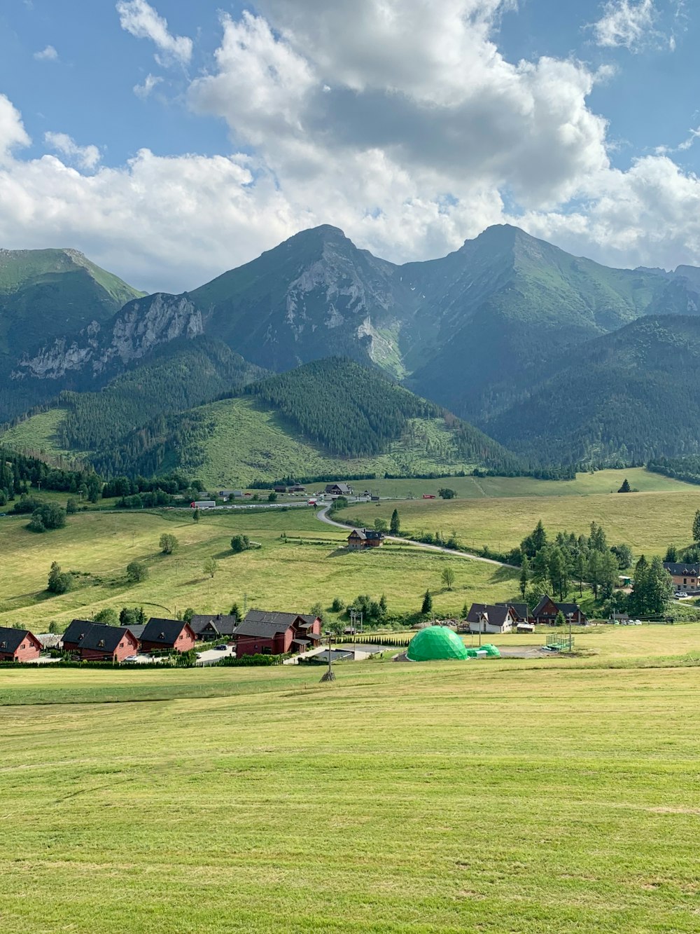 houses on grass near mountain