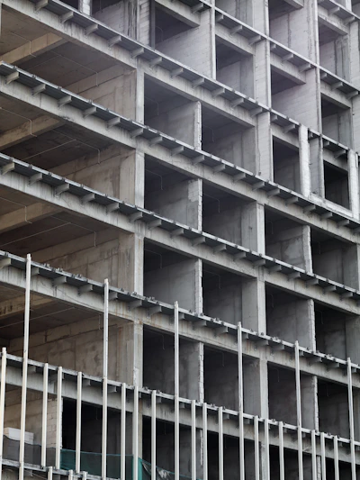 Concrete and steel framework of a commercial retail space under construction with visible tablaroca panels.