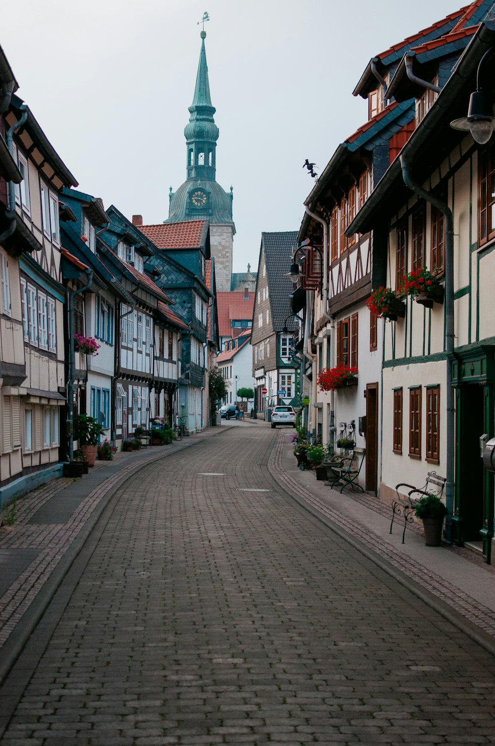 a cobblestone street with a clock tower in the background