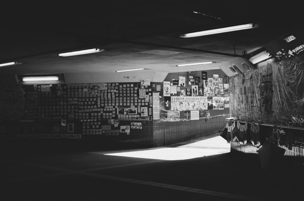 a black and white photo of a room with posters on the wall
