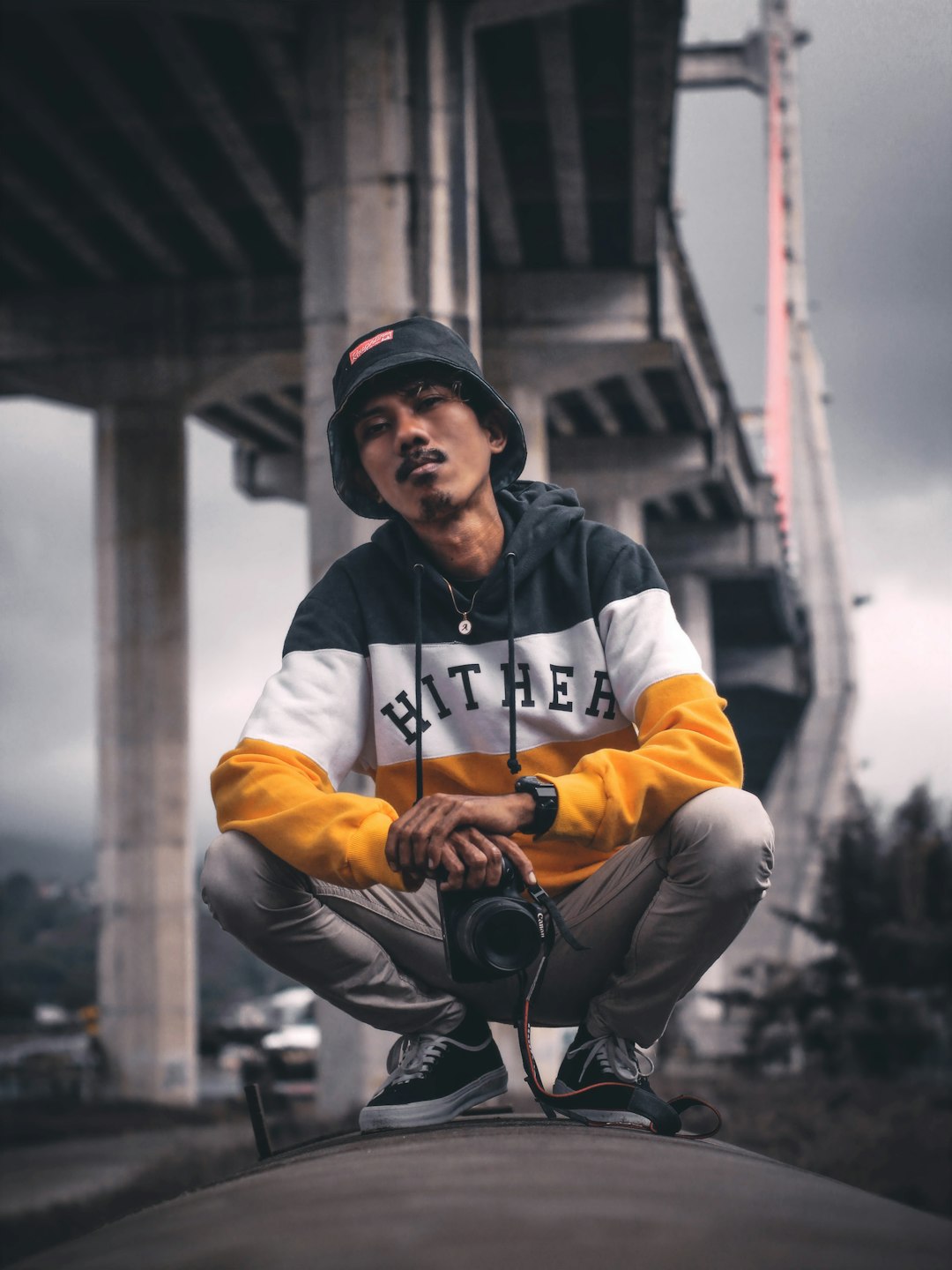 man wearing white, black, and yellow pullover hoodie almost sitting