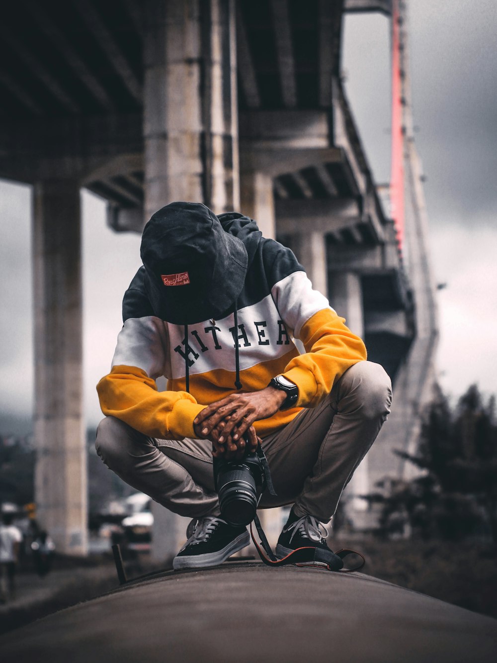 man wearing bucket hat holding DSLR camera