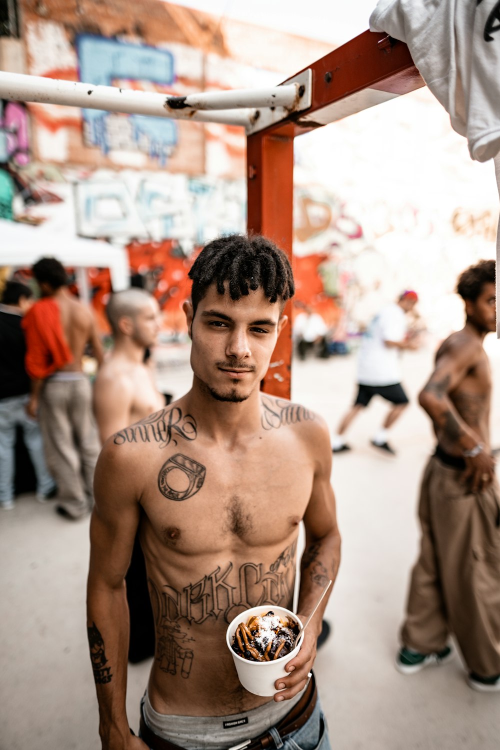 a shirtless man holding a bowl of food