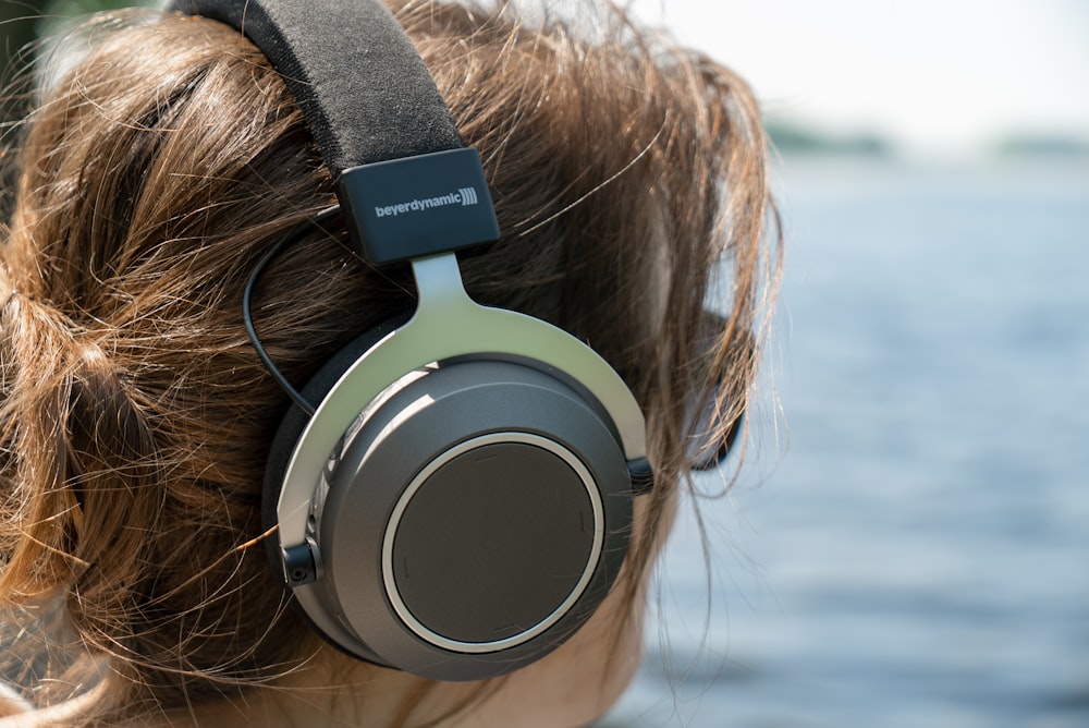 femme portant des écouteurs gris et argentés