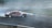 A vintage car with 'NANOPROTEC' branding is drifting on a race track, creating a plume of white smoke. The track has visible tire marks and is surrounded by blue and white barriers. The scene captures the dynamic motion and excitement of motorsport.