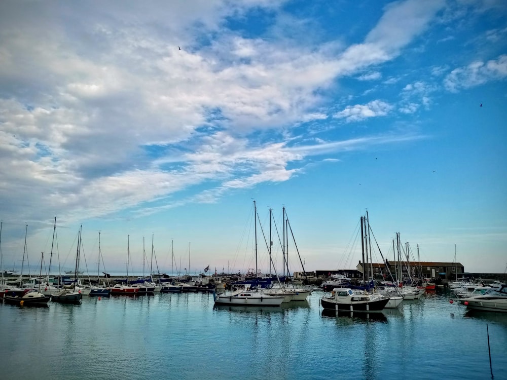 boat on body of water under white clouds and blue sky during daytime