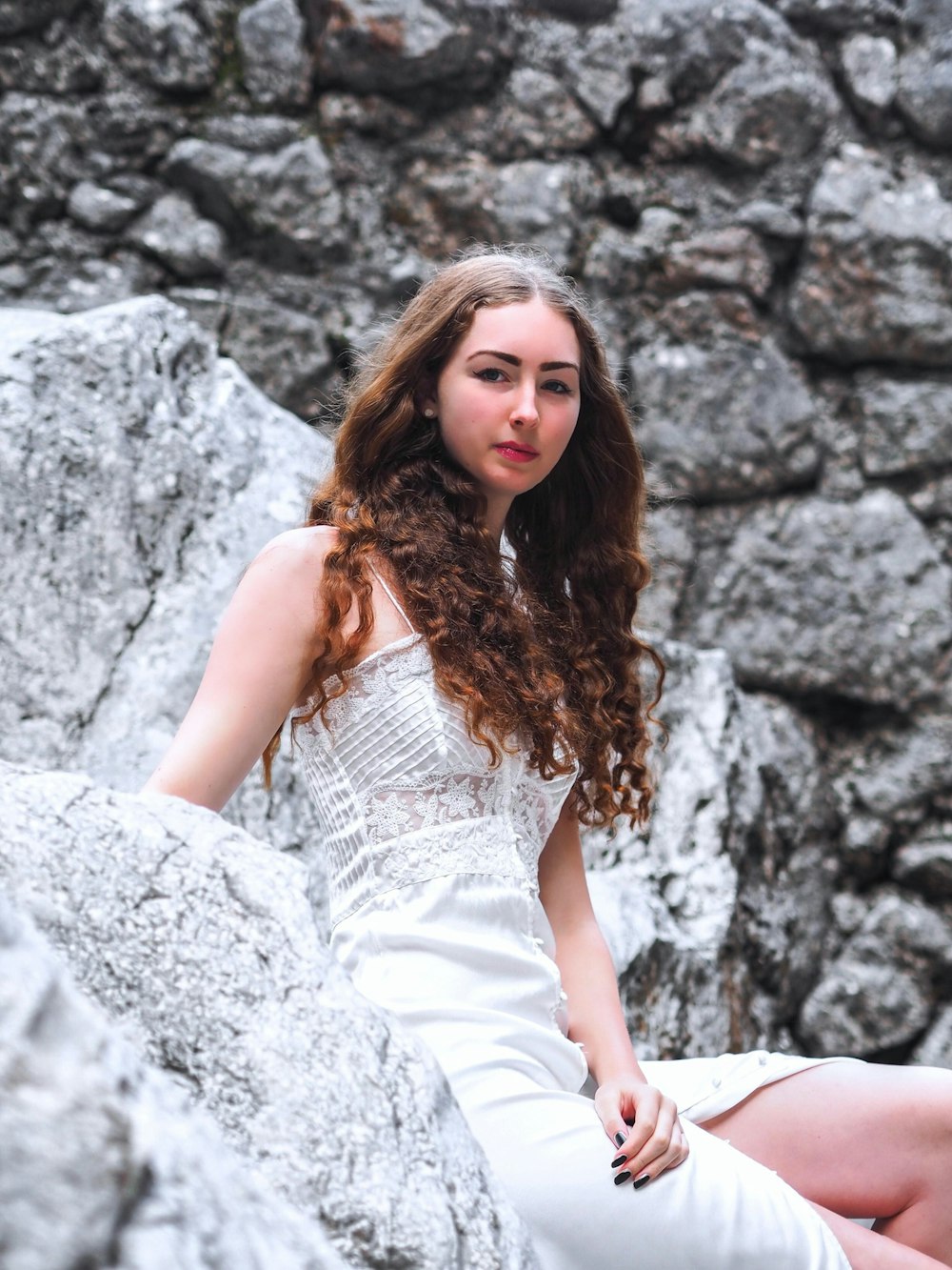 woman sitting on rock during daytime