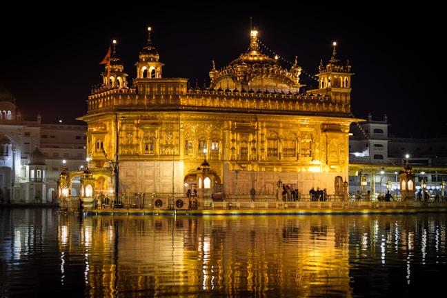A serene view of Kashi Vishwanath temple glowing at dusk with devotees in prayer.