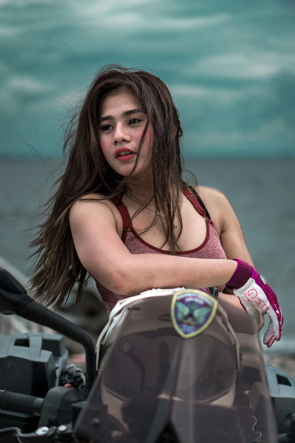 a woman with long hair sitting on a motorcycle