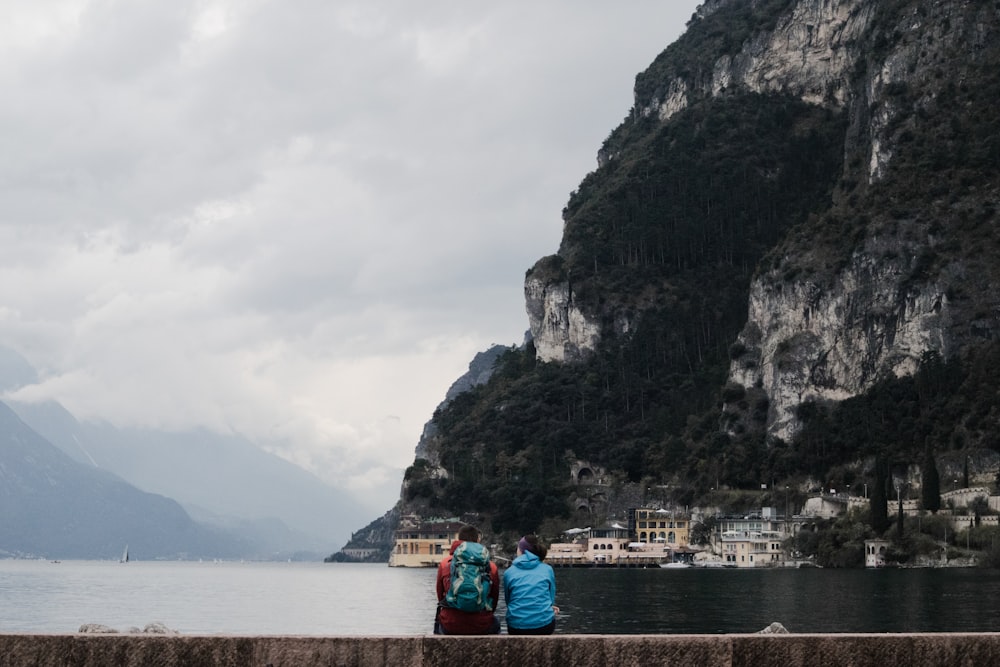 two person sitting on concrete bench