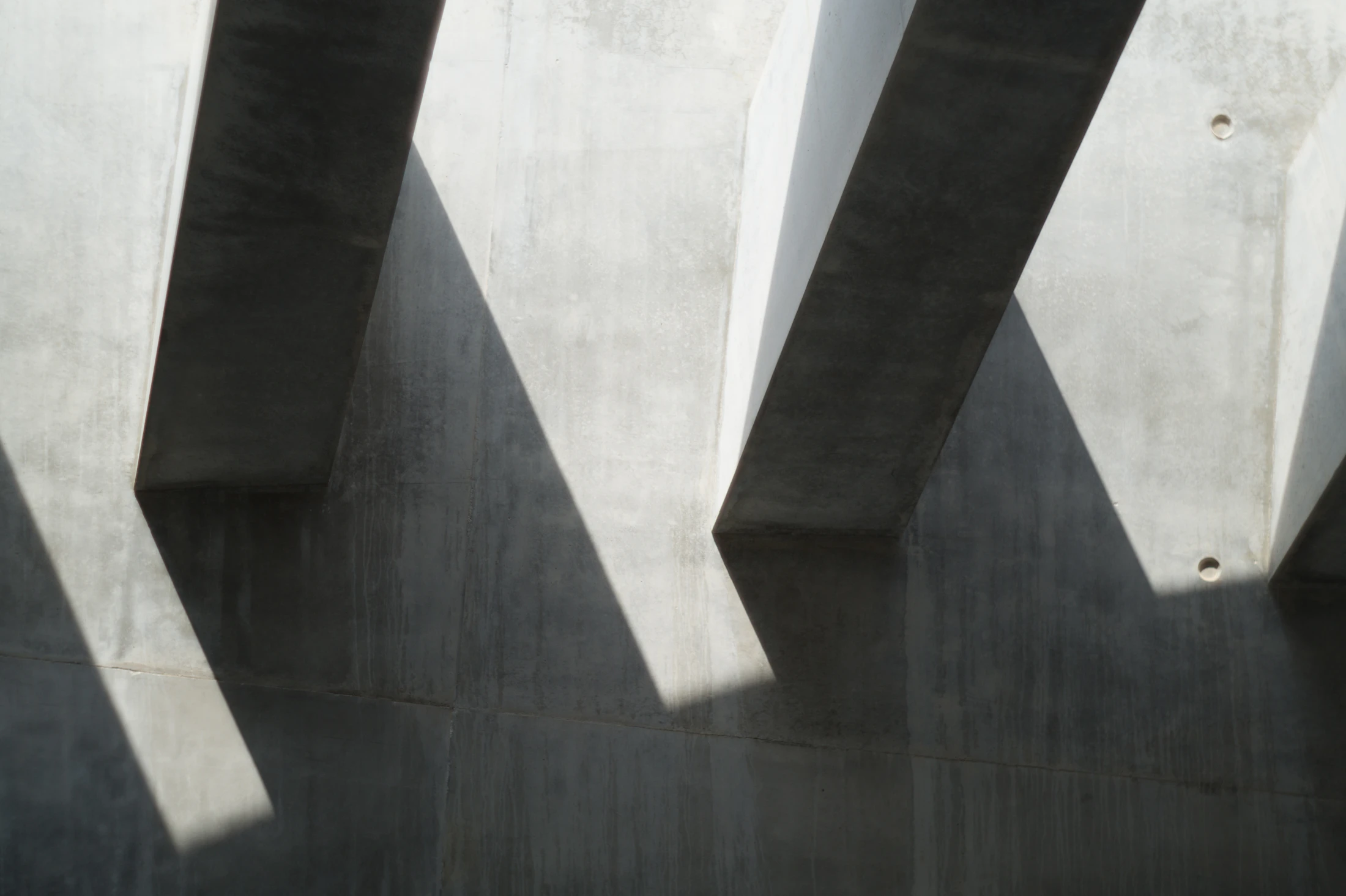 Shadows of a building falling across a concrete wall
