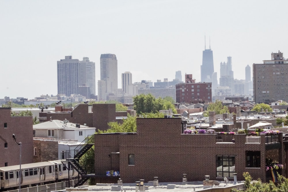 a train traveling through a city next to tall buildings